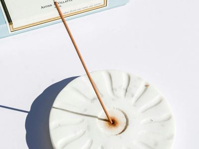 Incense sticks burning in a minimalist ceramic holder.